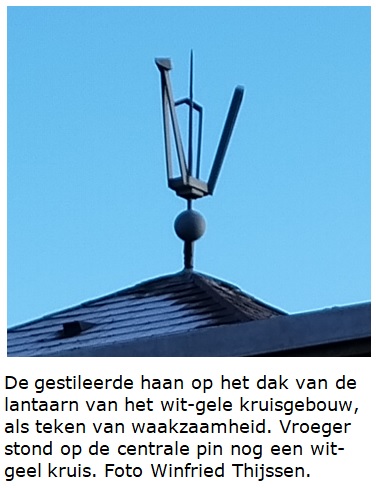 De gestileerde haan op het dak van de lantaarn van het wit-gele kruisgebouw, als teken van waakzaamheid. Vroeger stond op de centrale pin nog een wit-geel kruis. Foto Winfried Thijssen.